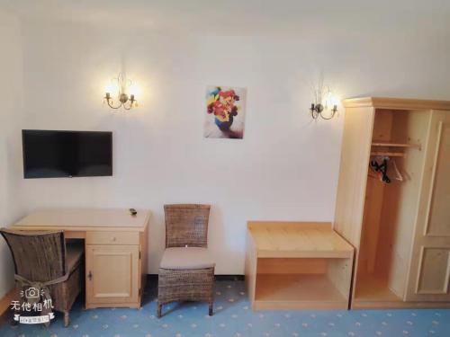 a room with a desk and a table and a tv at Pension Artstetten in Artstetten