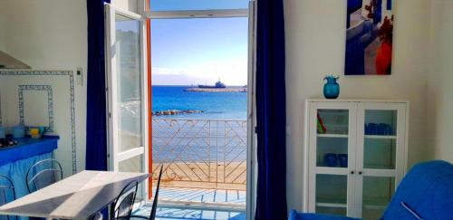 Una habitación con puerta abierta y vistas al océano en Maridea - In Riva al Mare, en Ponza