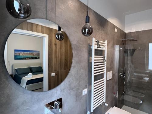łazienka z lustrem, łóżkiem i prysznicem w obiekcie The Pellis w mieście Monopoli