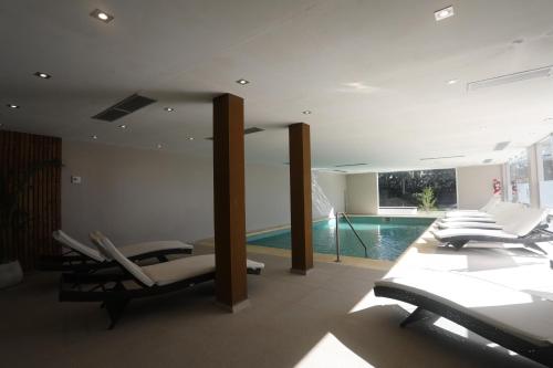 a living room with a swimming pool and lounge chairs at Howard Johnson Plaza & Convention Center Spa La Plata in La Plata