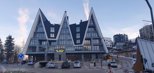 a large building with triangular windows in a city at Apartman" AROMA 2 "Bjelasnica in Bjelašnica