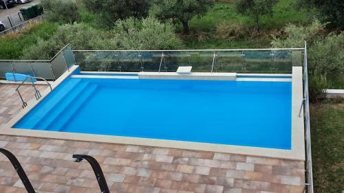 a large swimming pool with blue water in a yard at Apartma Coccolo in Zambratija