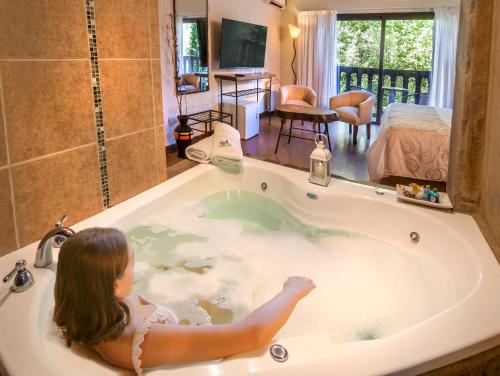 a little girl is sitting in a bath tub at Posada del Sauce in Villa General Belgrano