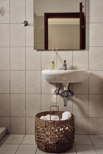 a bathroom with a sink and a basket with towels at Razis Apartments in Tsilivi