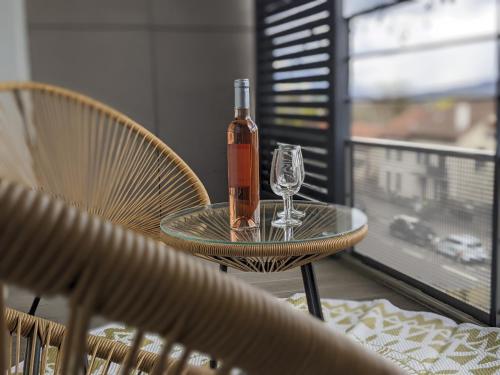 - une bouteille de vin assise sur une table avec un verre dans l'établissement Cocon Annécien entre lac et montagne classé 1 étoile, à Annecy