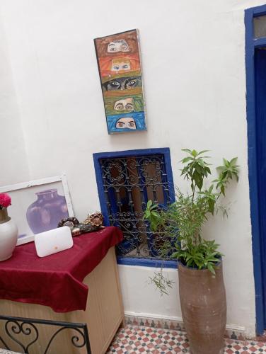 a room with a table and a window and a plant at RIAD DAR LFONOUN in Marrakech