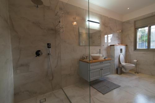 y baño con ducha, lavabo y aseo. en King's bed - Stay Royal and Stylish Bahai's Garden, en Haifa
