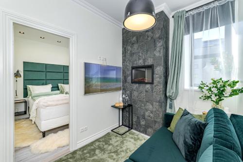 a living room with a blue couch and a bedroom at Tallinn City Harbour Apartments in Tallinn