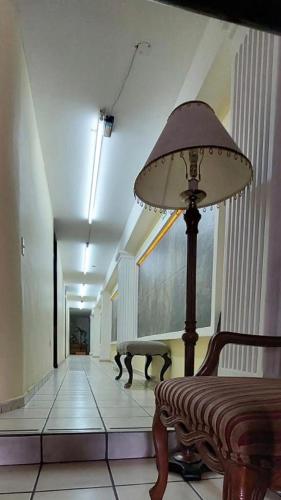 a hallway with a lamp and a bench in a building at Hotel el Cortes in Aguascalientes