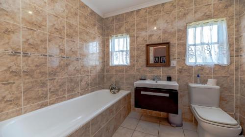 a bathroom with a tub and a toilet and a sink at Seaside At 22 Sandpiper in Ballito