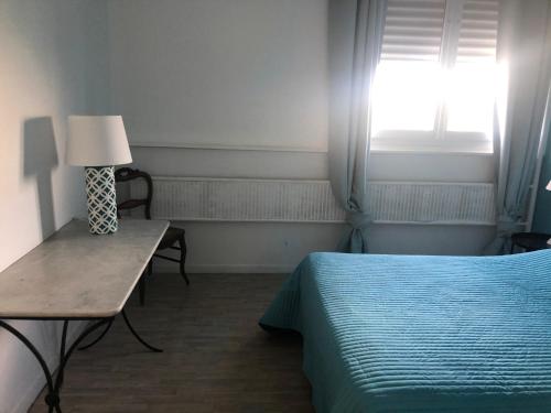 a bedroom with a bed and a table with a lamp at F3 Metare / Fraissinette IRUP-Ecole des Mines in Saint Etienne