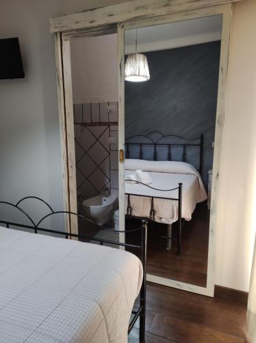 a bedroom with a bed and a sink and a mirror at B&b La Fontana Borbone in Lauria