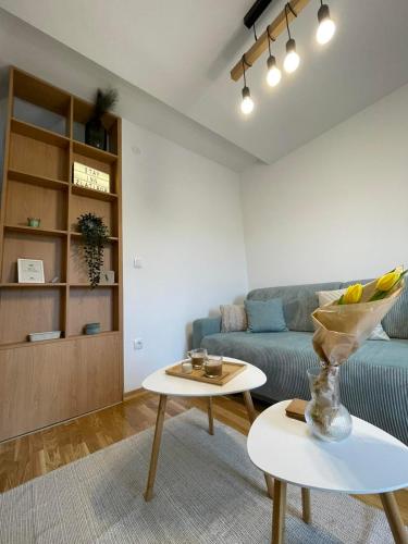 a living room with a blue couch and a table at Stay Inn Zlatibor in Zlatibor