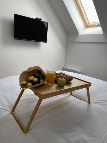 a coffee table with a bowl of fruit and a glass of orange juice at Stay Inn Zlatibor in Zlatibor