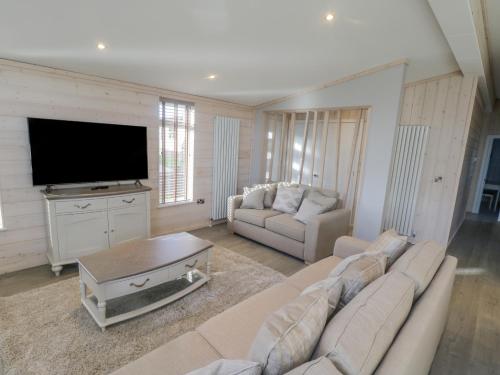 a living room with a couch and a flat screen tv at No 27 The Crab Pot in Saltburn-by-the-Sea