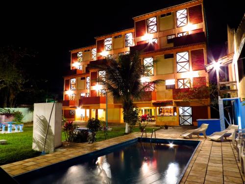 a hotel with a swimming pool in front of a building at Apart-Hotel Marinas da Lagoa - 2 Praias a 4 Min - in Saquarema