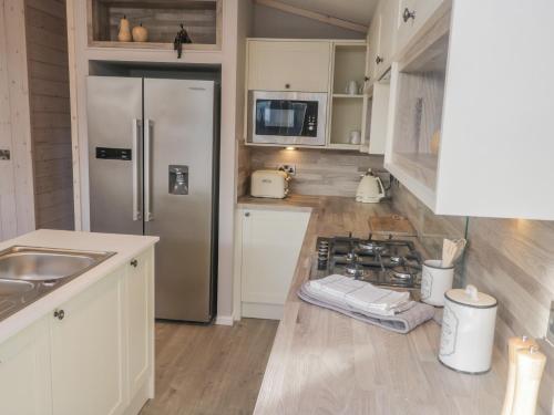 a kitchen with a stainless steel refrigerator and wooden floors at No 27 The Crab Pot in Saltburn-by-the-Sea