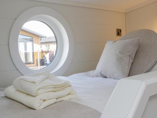 a bedroom with a mirror and a white bed at No 27 The Crab Pot in Saltburn-by-the-Sea