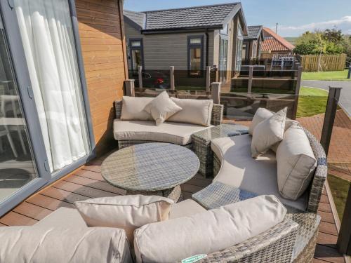 a patio with couches and a table on a deck at No 27 The Crab Pot in Saltburn-by-the-Sea