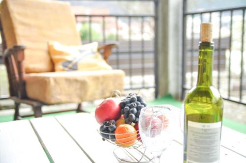 a bottle of wine and a bowl of fruit on a table at Apartment Dino in Konjic