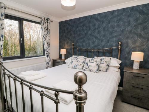 a bedroom with a bed and a blue wall at Mayflower in Lifton