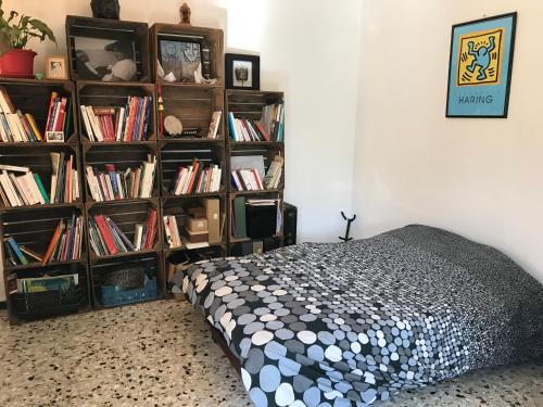 - une chambre avec un lit et des étagères remplies de livres dans l'établissement Chez Val & Dam, à Avignon