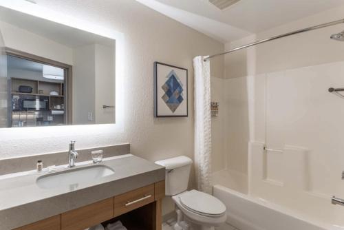 ein Badezimmer mit einem Waschbecken, einem WC und einem Spiegel in der Unterkunft Candlewood Suites Ofallon, Il - St. Louis Area, an IHG Hotel in O'Fallon