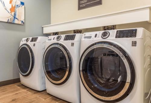 three washing machines sitting next to each other in a laundry room at Candlewood Suites Ofallon, Il - St. Louis Area by IHG in O'Fallon