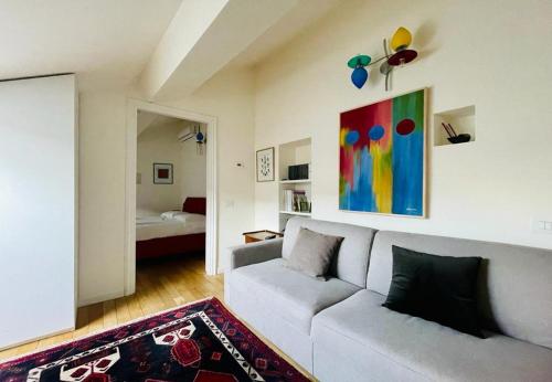 ein Wohnzimmer mit einem Sofa und einem Gemälde an der Wand in der Unterkunft Appartamento Rossini by Holiday Solutions in Como