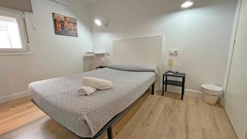 ein Schlafzimmer mit einem Bett mit einem weißen Handtuch darauf in der Unterkunft Hostal La Premsa in Arenys de Mar