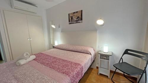 a small bedroom with two beds and a chair at Hostal La Premsa in Arenys de Mar