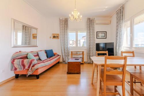 a living room with a couch and a table at Paço de Arcos Apartment in Paço de Arcos