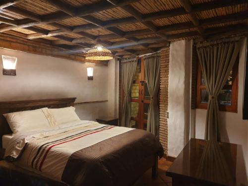 a bedroom with a bed and a chandelier at Casona Real Santa Barbara in Ráquira