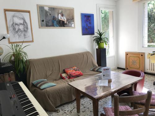 - un salon avec un canapé, une table et un piano dans l'établissement Chez Val & Dam, à Avignon