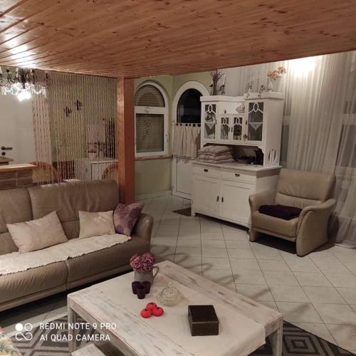 a living room with a couch and a table at Lavendel Apartman in Harkány