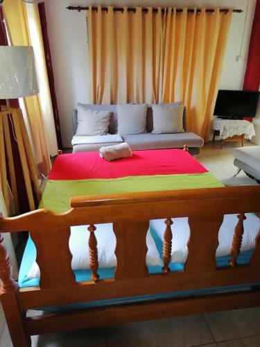 a large bed in a living room with a couch at Creole Cottage Homestay in Mahe