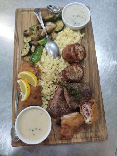 a plate of food with meat and vegetables on a table at Schloss in Mursko Središće