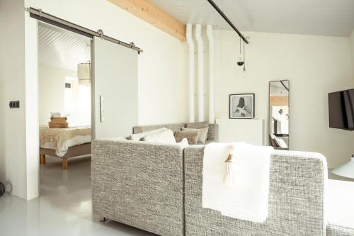 een woonkamer met een bank en een spiegel bij Appartementen Zer en Loft in centrum Bergen in Bergen