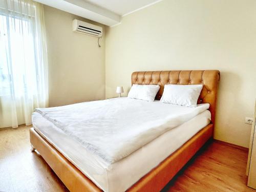 a bedroom with a large bed with white sheets and a window at Adriatique Apartments in Dobra Voda