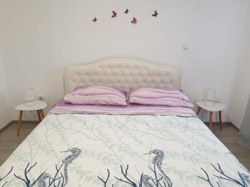 a bedroom with a bed with purple sheets and two tables at Apartment Antonia in Šibenik