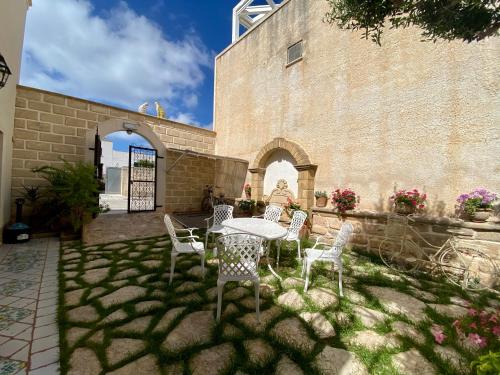 un patio con mesa y sillas junto a un edificio en Guest House Al Gattopardo en Favignana
