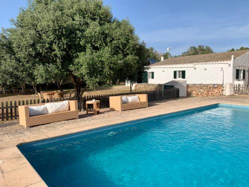 una piscina con 2 tumbonas junto a una casa en Islanders Menorca Country Club, en Son Carrio