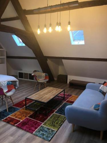 un salon avec un canapé et une table basse dans l'établissement Suite de charme au pied de la cathédrale, à Laon
