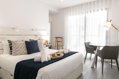 a bedroom with a large bed with a table and chairs at Consolação Supertubos Beach Apartment in Consolação