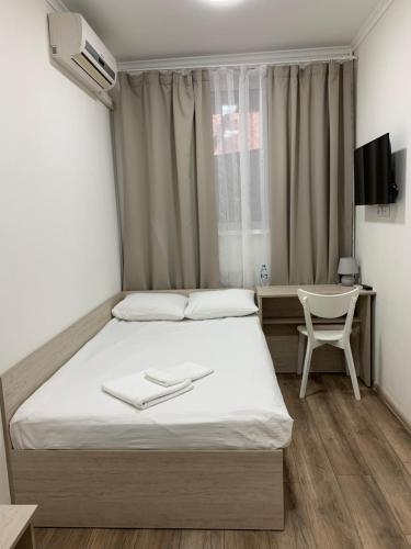 a bedroom with a bed and a desk and a chair at Міні-Готель Білий Квадрат in Kyiv