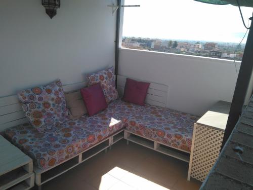 un sofá sentado frente a una gran ventana en Ático Dúplex con vistas en Murcia