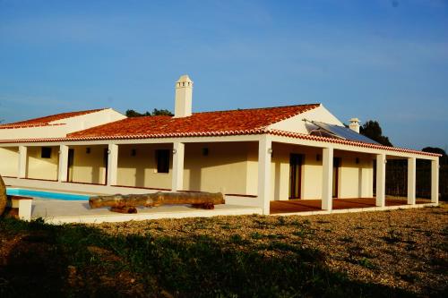 duży biały dom z basenem przed nim w obiekcie Monte do Pantaleão w mieście Baleizão