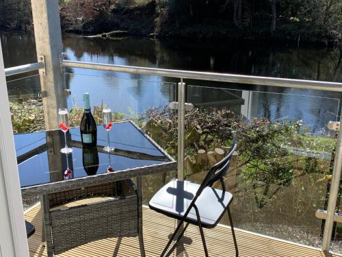 a glass of wine sitting on a table on a balcony at Tanllan Apartment in Callander