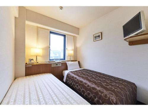 a hotel room with a bed and a flat screen tv at Urayasu Sun Hotel - Vacation STAY 33022v in Urayasu
