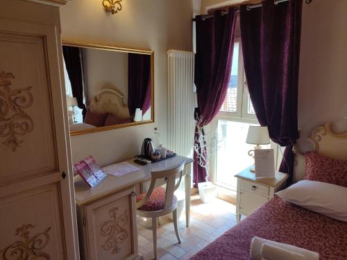a bedroom with a bed and a desk and a mirror at Casa Aurora in Ravenna